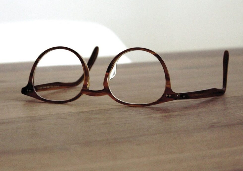 Round reading glasses with brown tortoise shell frame on a wooden table, assortment for reading glasses wholesale.
