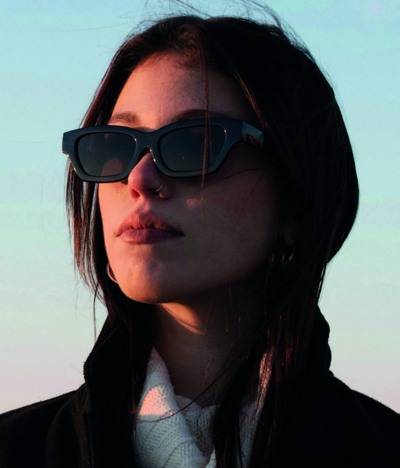 Vrouw met een stijlvolle zwarte zonnebril en gepolariseerde glazen tijdens de zonsondergang.