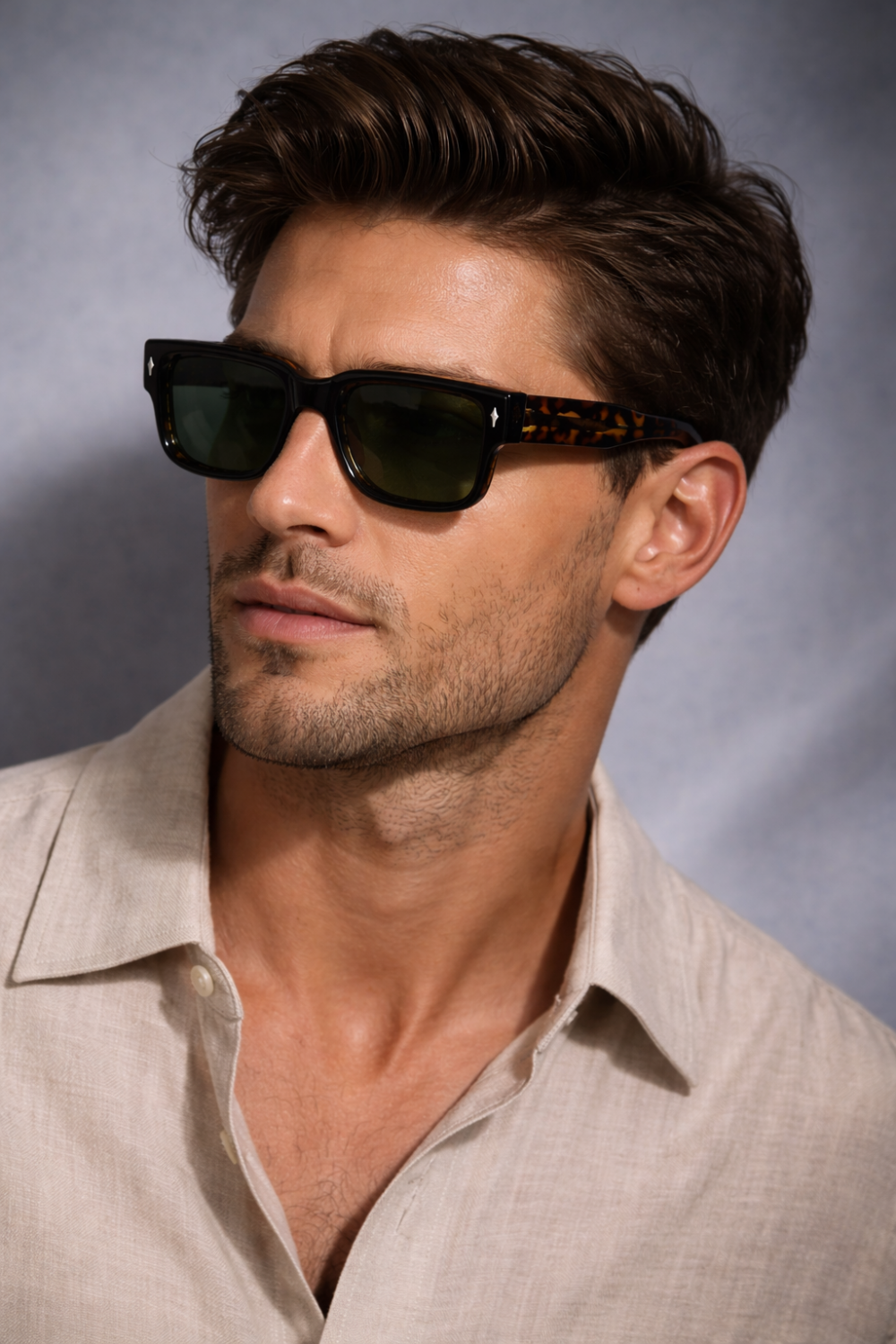 Hombre de pelo castaño, lleva gafas de propionato de celulosa con dibujo de tortuga y camisa de lino beige.